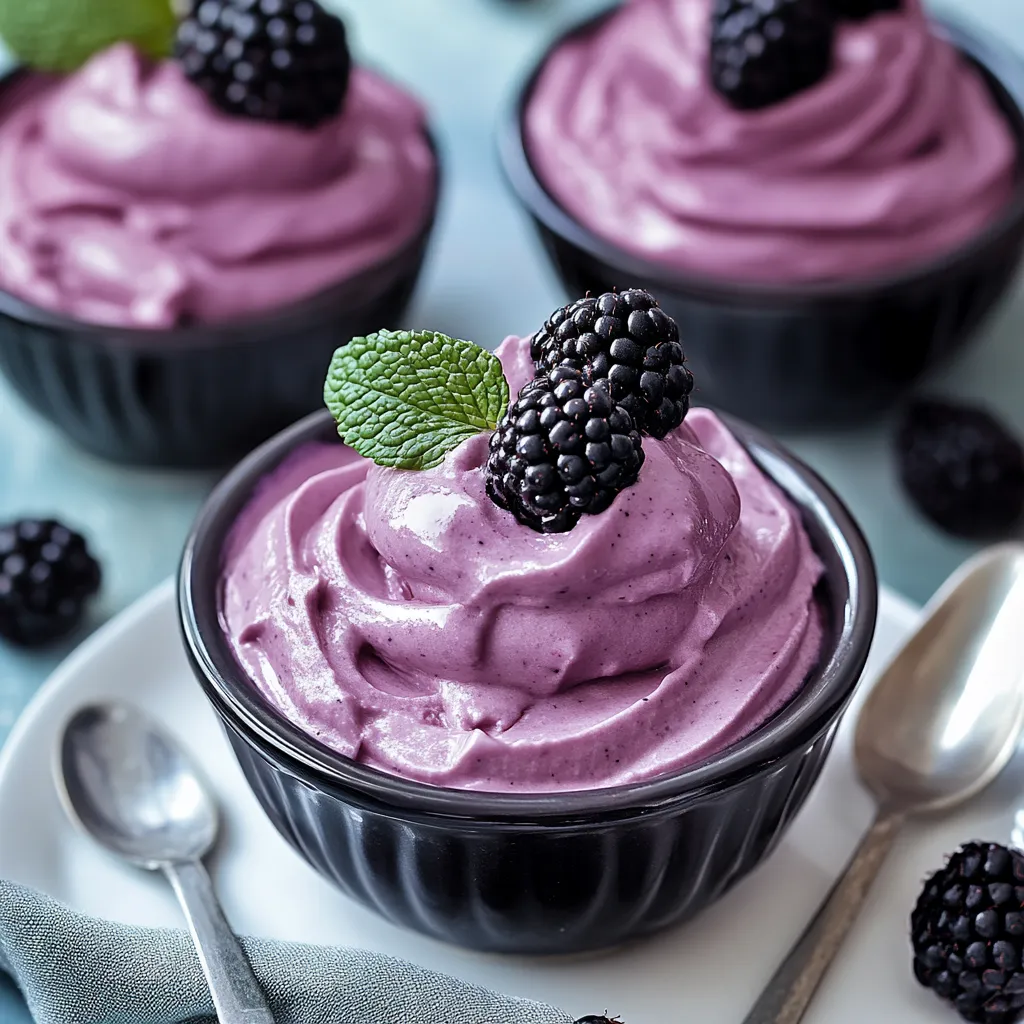 Una taza de yogur con moras y una cuchara.
